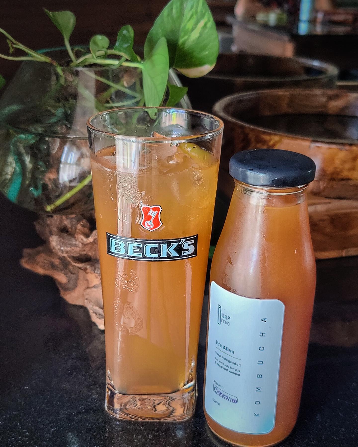 Burp Me kombucha bottle beside a glass of kombucha